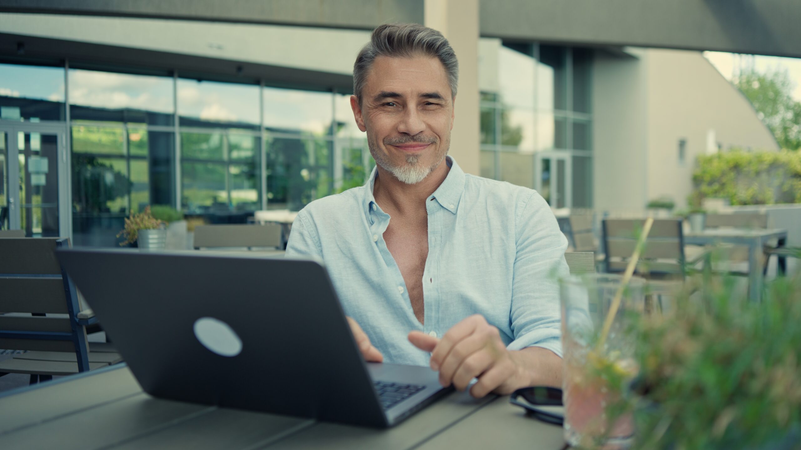 Smiling middle-aged freelancer working on laptop